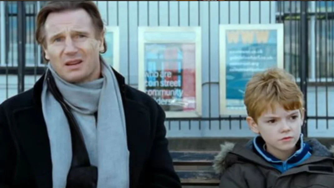 Σκηνή από την ταινία Love Actually με έναν άνδρα και ένα αγόρι σε παγκάκι.