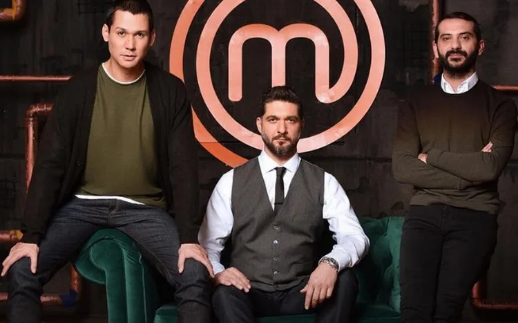 Τρεις κριτές του MasterChef σε στούντιο με το λογότυπο της εκπομπής.