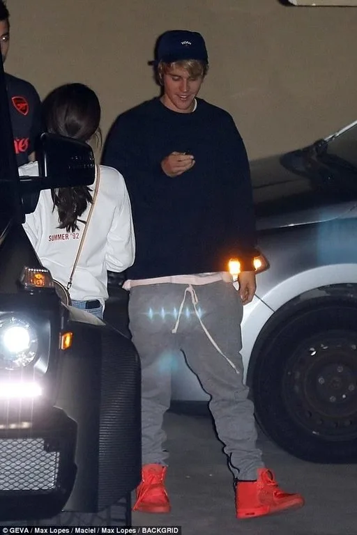 Ο Justin Bieber και η Selena Gomez σε βραδινή έξοδο δίπλα σε αυτοκίνητο.