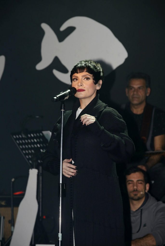Η Ελεωνόρα Ζουγανέλη με κοντό μαύρο μαλλί τραγουδάει σε μικρόφωνο.