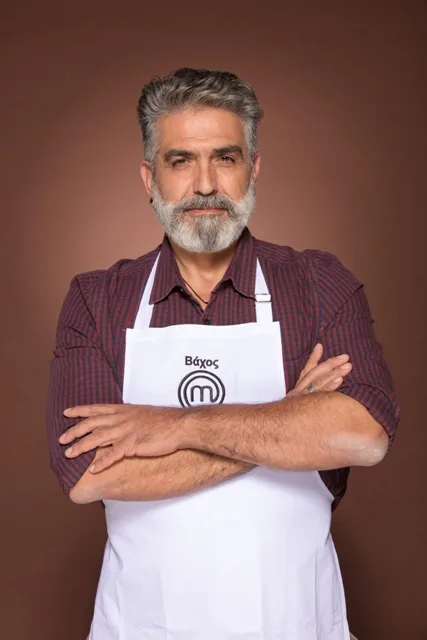 Παίκτης του MasterChef 2 με λευκή ποδιά και σταυρωμένα χέρια.