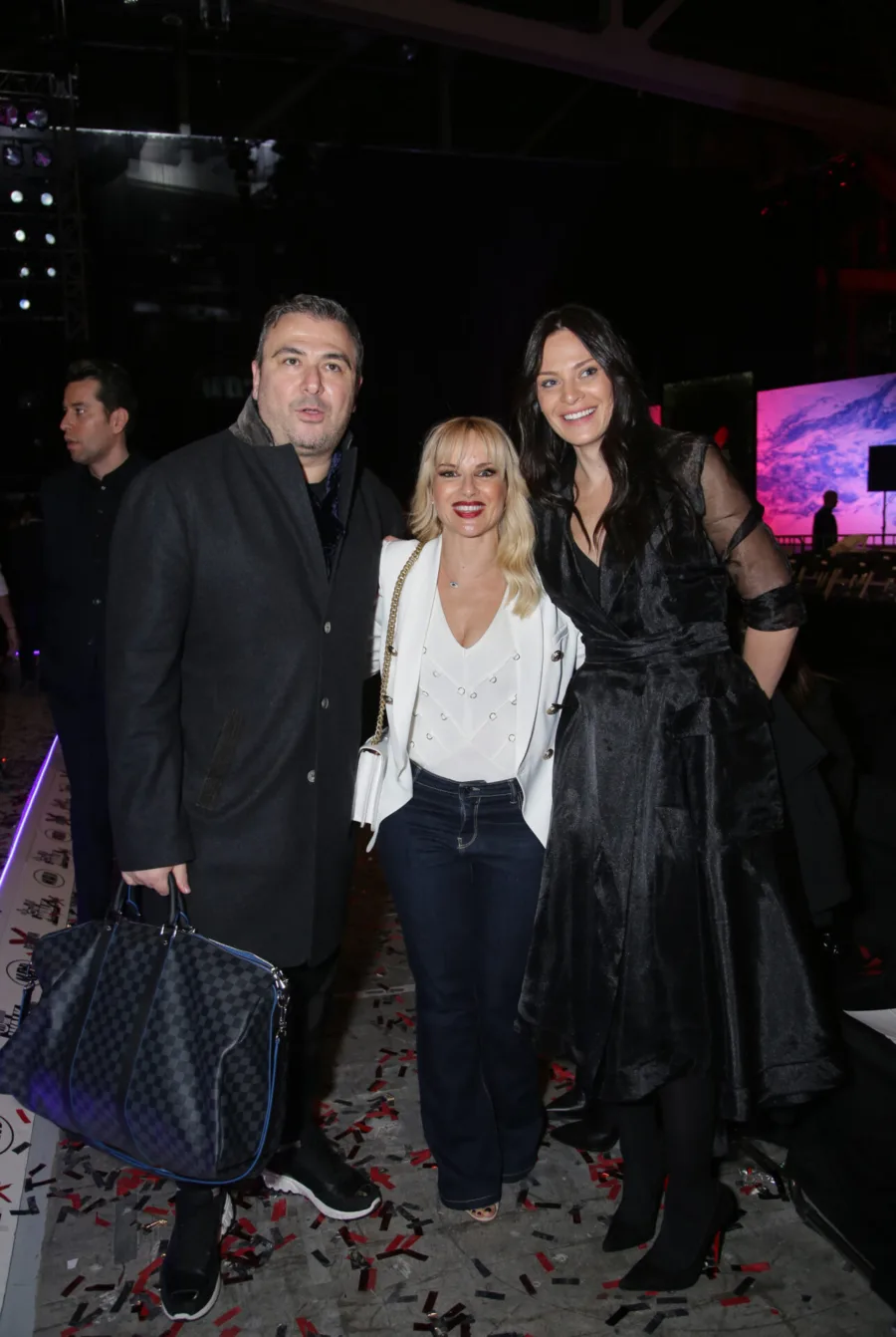 Τρία άτομα ποζάρουν στο after party του MadWalk.