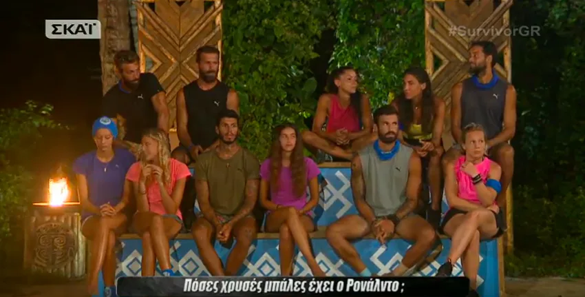 Παίκτες του Survivor 2 κάθονται σε πάγκους κατά τη διάρκεια συμβουλίου του νησιού.
