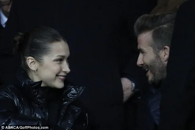 Ο David Beckham και η Bella Hadid σε κοντινό πλάνο να συνομιλούν χαμογελαστοί.