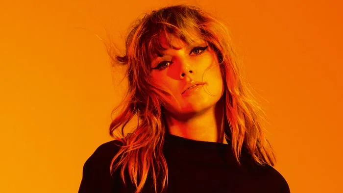 Η Taylor Swift σε πορτρέτο με έντονο πορτοκαλί φωτισμό.
