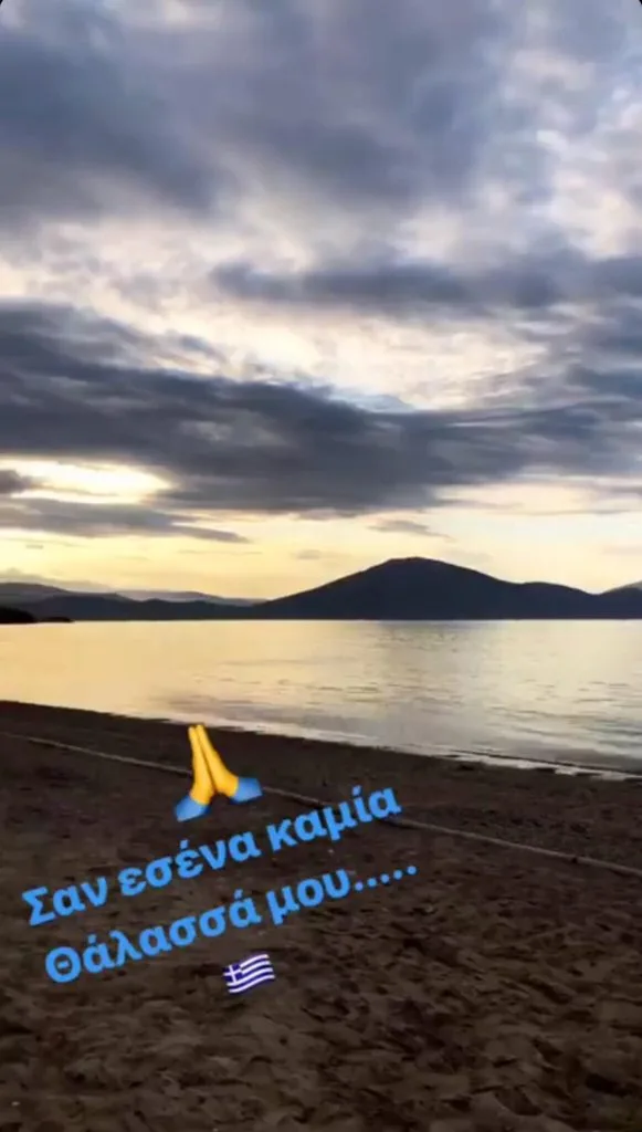 Παραλία κατά το ηλιοβασίλεμα με κείμενο στα ελληνικά.