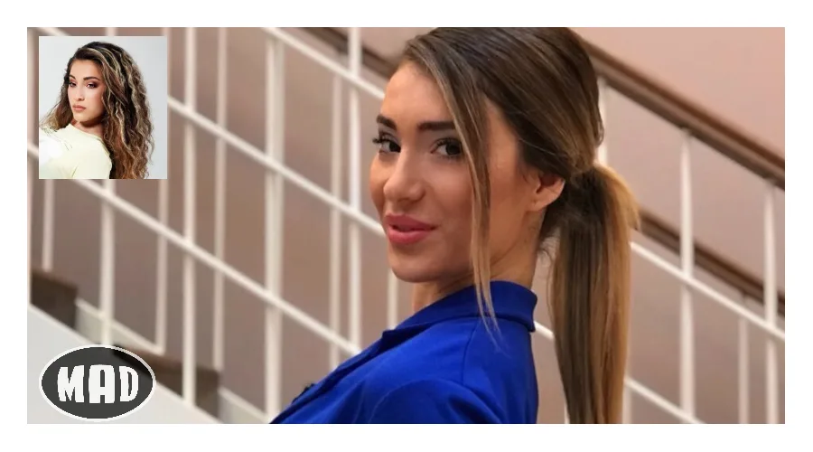 Νεαρή γυναίκα με μπλε ρούχο και αλογοουρά μπροστά από σκάλα.