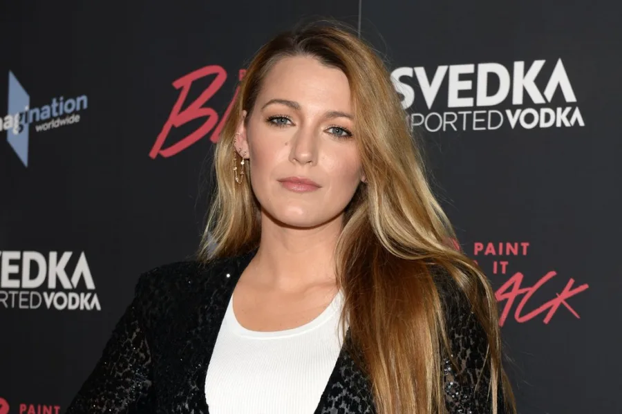 Η Blake Lively ποζάρει σε εκδήλωση με μαύρο σακάκι και λευκό τοπ.