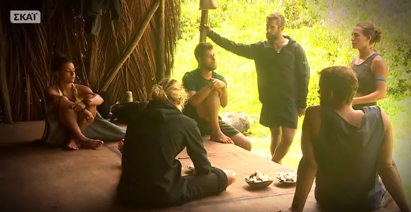 Παίκτες του Survivor σε συζήτηση μέσα σε καλύβα.