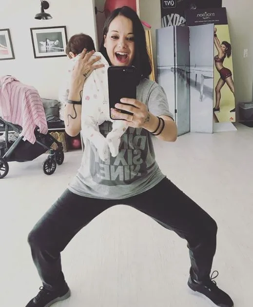 Γυναίκα βγάζει selfie στον καθρέφτη κρατώντας ένα μωρό στην αγκαλιά της.