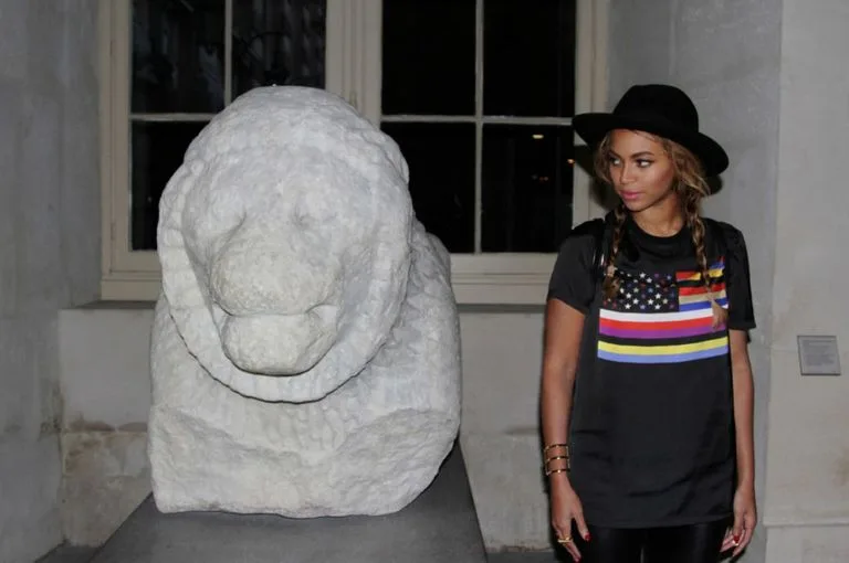 Η Beyonce δίπλα σε ένα μαρμάρινο άγαλμα λιονταριού στο Μουσείο του Λούβρου.