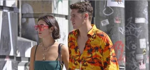 Η Dua Lipa και ο Isaac Carew περπατούν στο δρόμο.