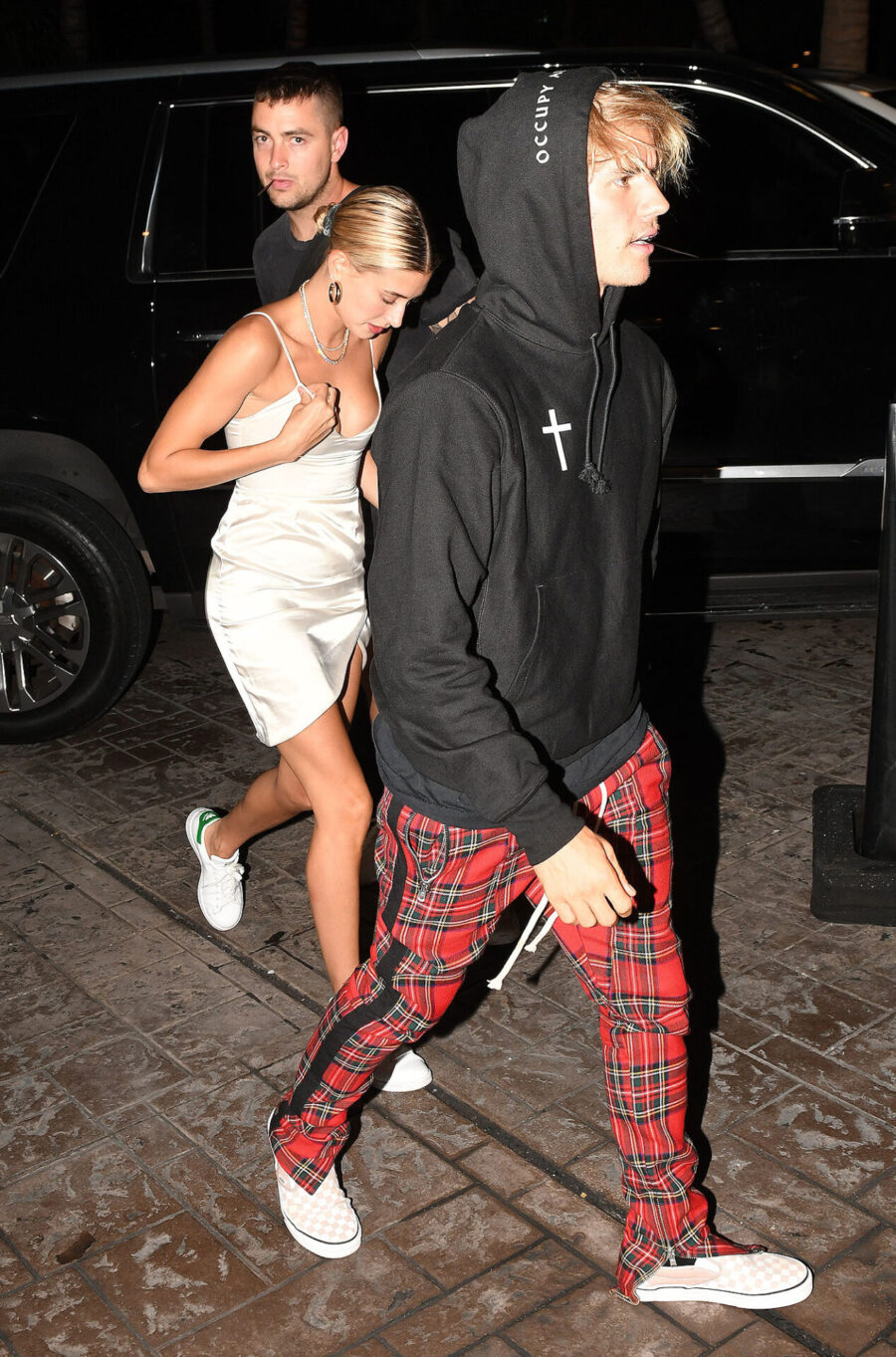 Ο Justin Bieber και η Hailey Baldwin περπατούν έξω το βράδυ.
