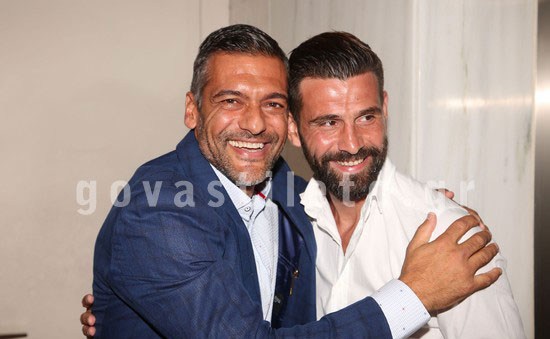 Ο Στέλιος Κρητικός αγκαλιά με έναν άνδρα σε εκδήλωση.