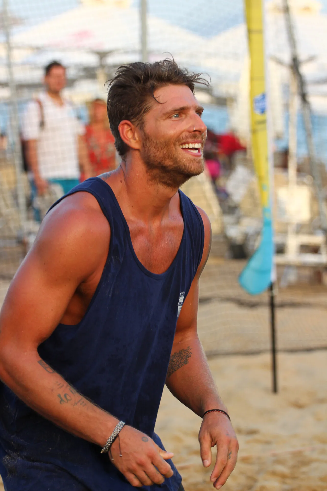 Άνδρας με μπλε αμάνικη μπλούζα σε αγώνα beach volley.