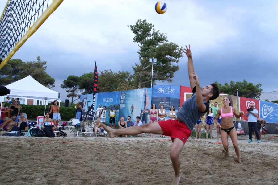 Στιγμιότυπο από αγώνα beach volley με παίκτη να κάνει άλμα για να χτυπήσει την μπάλα.