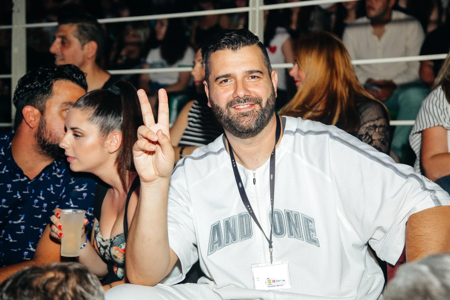 Άνδρας με λευκή μπλούζα And One κάνει το σήμα της νίκης στα Mad Video Music Awards 2018.
