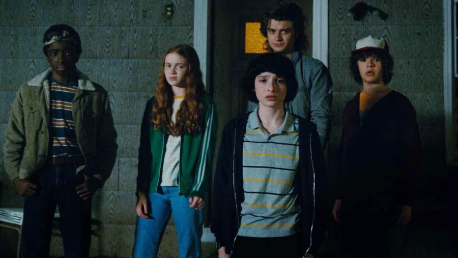 Πρωταγωνιστές της σειράς Stranger Things σε εξωτερικό χώρο τη νύχτα.