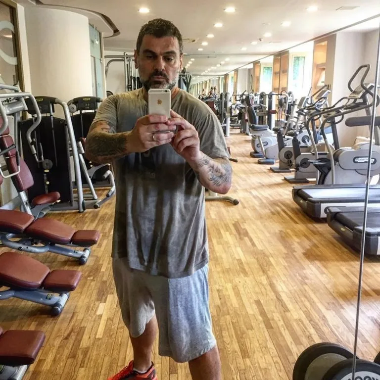 Ο Τόνυ Μαυρίδης ποζάρει στον καθρέφτη του γυμναστηρίου, δείχνοντας την αλλαγή του σήμερα.