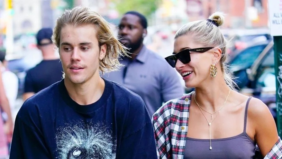 Ο Justin Bieber και η Hailey Baldwin περπατούν στο δρόμο.