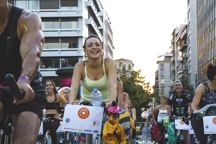 Πλήθος κόσμου συμμετέχει σε υπαίθρια εκδήλωση στατικής ποδηλασίας σε κεντρικό δρόμο της πόλης.