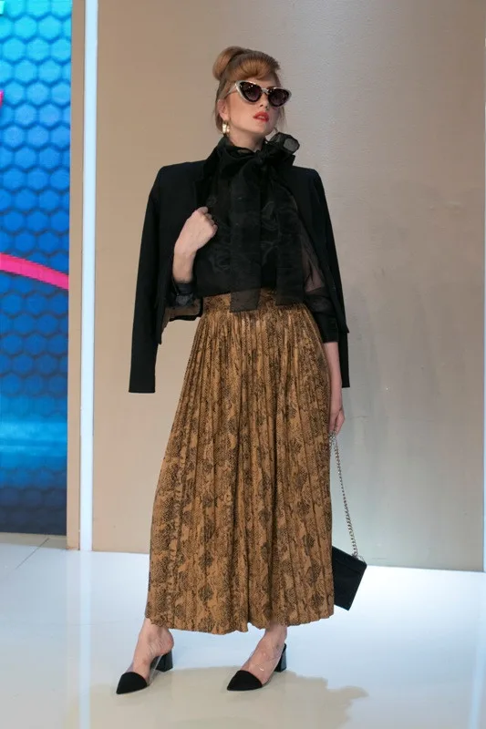 Παίκτρια του My Style Rocks 2 με μαύρο σακάκι, πουκάμισο με φιόγκο και μακριά πλισέ φούστα με animal print.