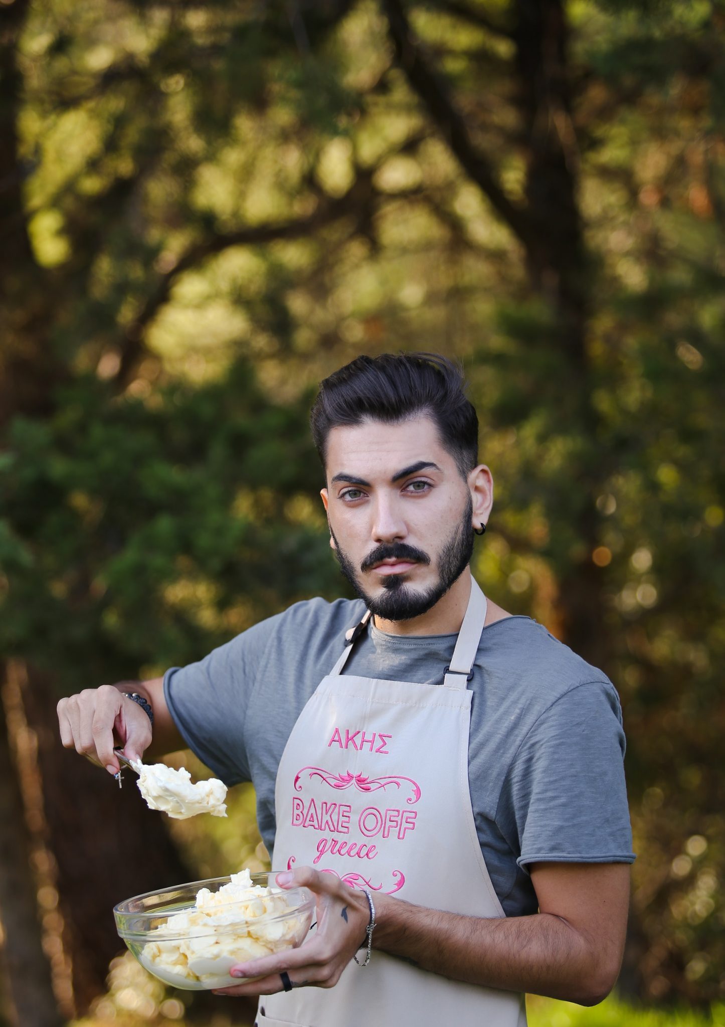 Ο Άκης από το Bake Off Greece κρατάει ένα μπολ με κρέμα.