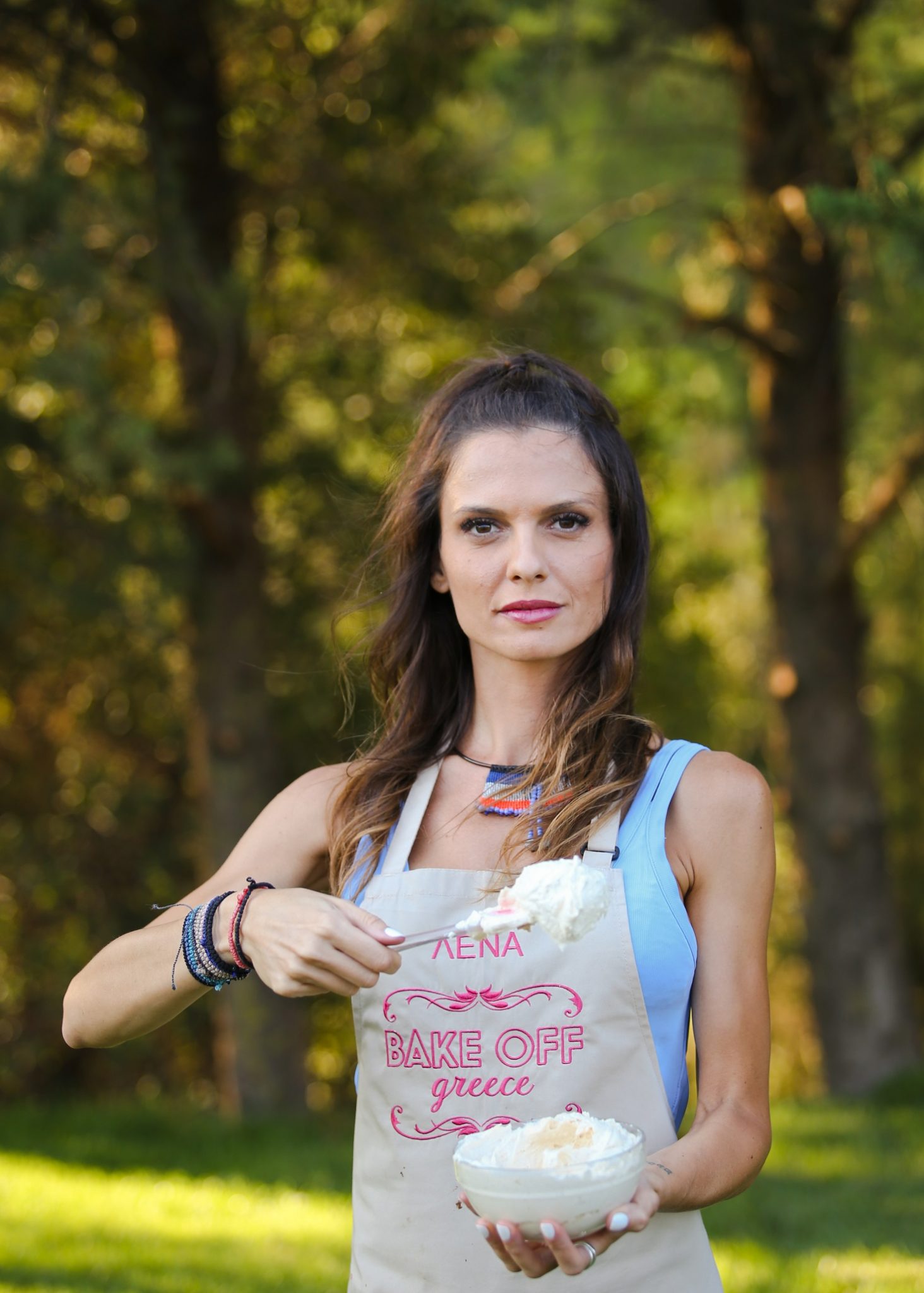 Παίκτρια του Bake Off Greece με ποδιά και μπολ με κρέμα.