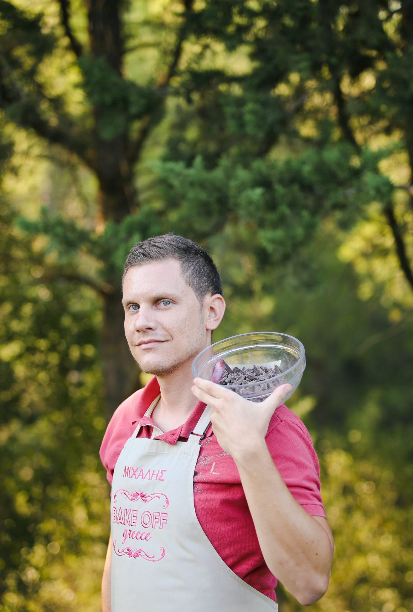 Ο Μιχάλης από το Bake Off Greece κρατάει ένα μπολ με κομμάτια σοκολάτας.