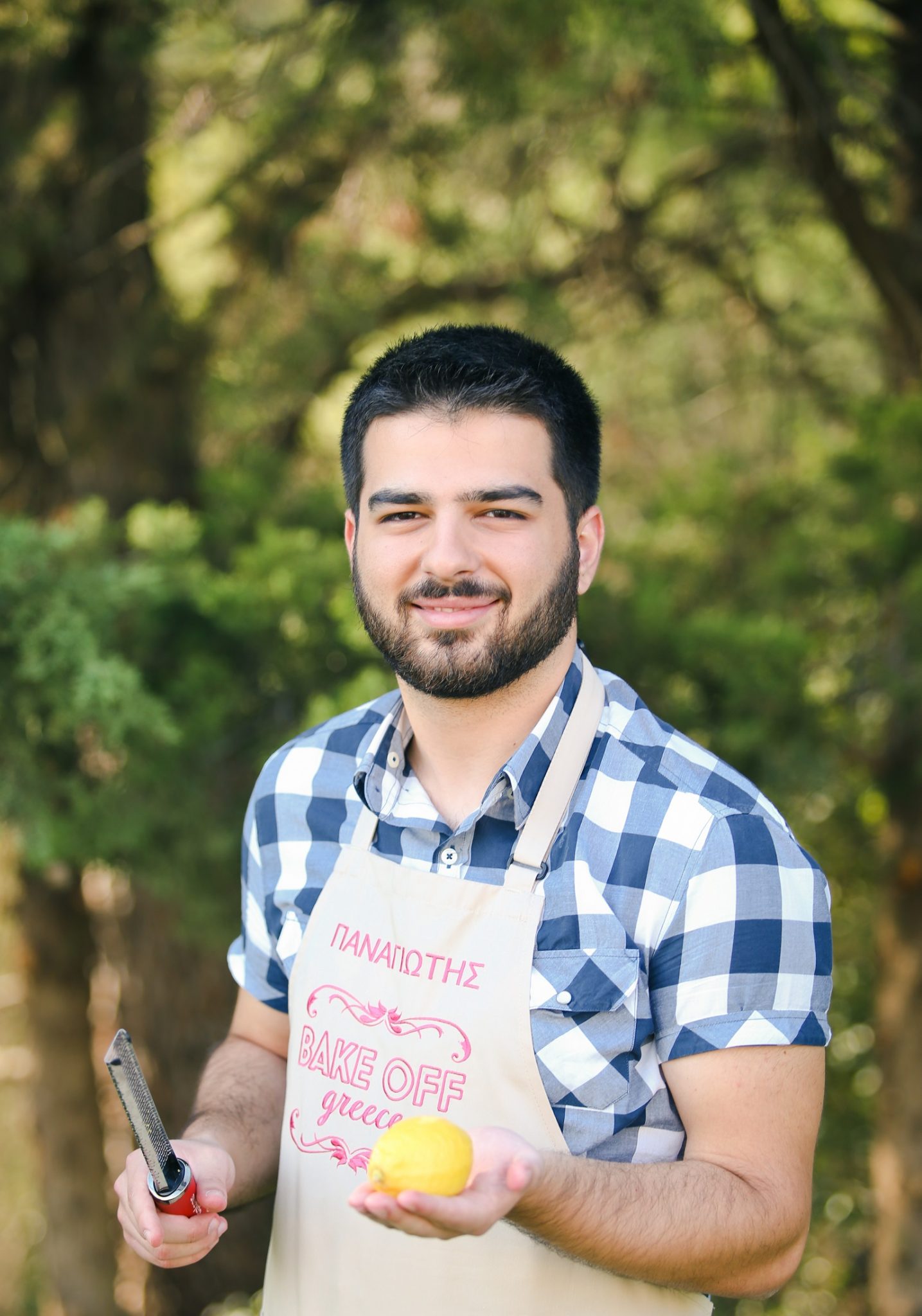 Ο Παναγιώτης, παίκτης του Bake Off Greece, κρατάει ένα λεμόνι και έναν τρίφτη.
