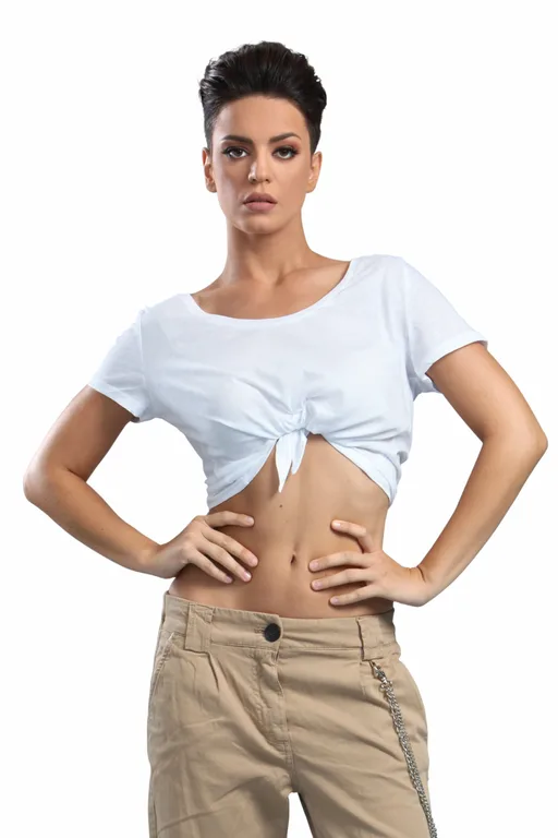 Παίκτρια του Nomads Μαδαγασκάρη με λευκό crop top και μπεζ παντελόνι.