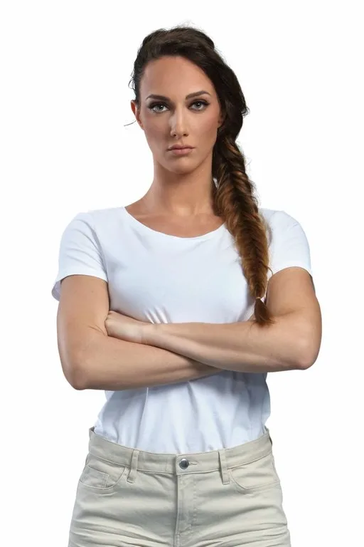 Γυναίκα με πλεξούδα ψαροκόκαλο και λευκό t-shirt με σταυρωμένα χέρια.