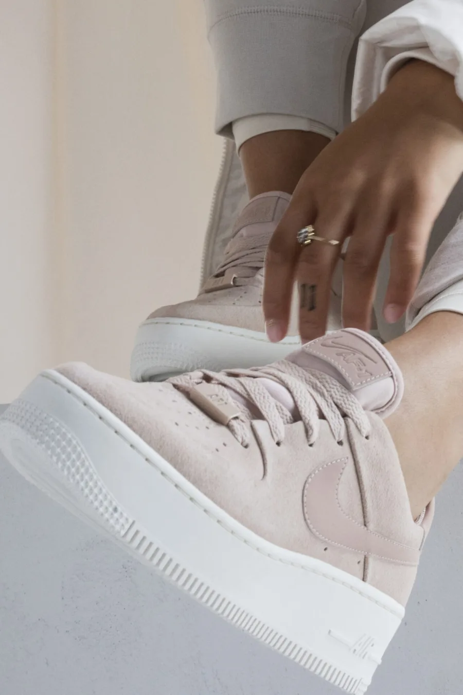 Κοντινό πλάνο στα Nike Air Force 1 Sage σε απαλό ροζ χρώμα.