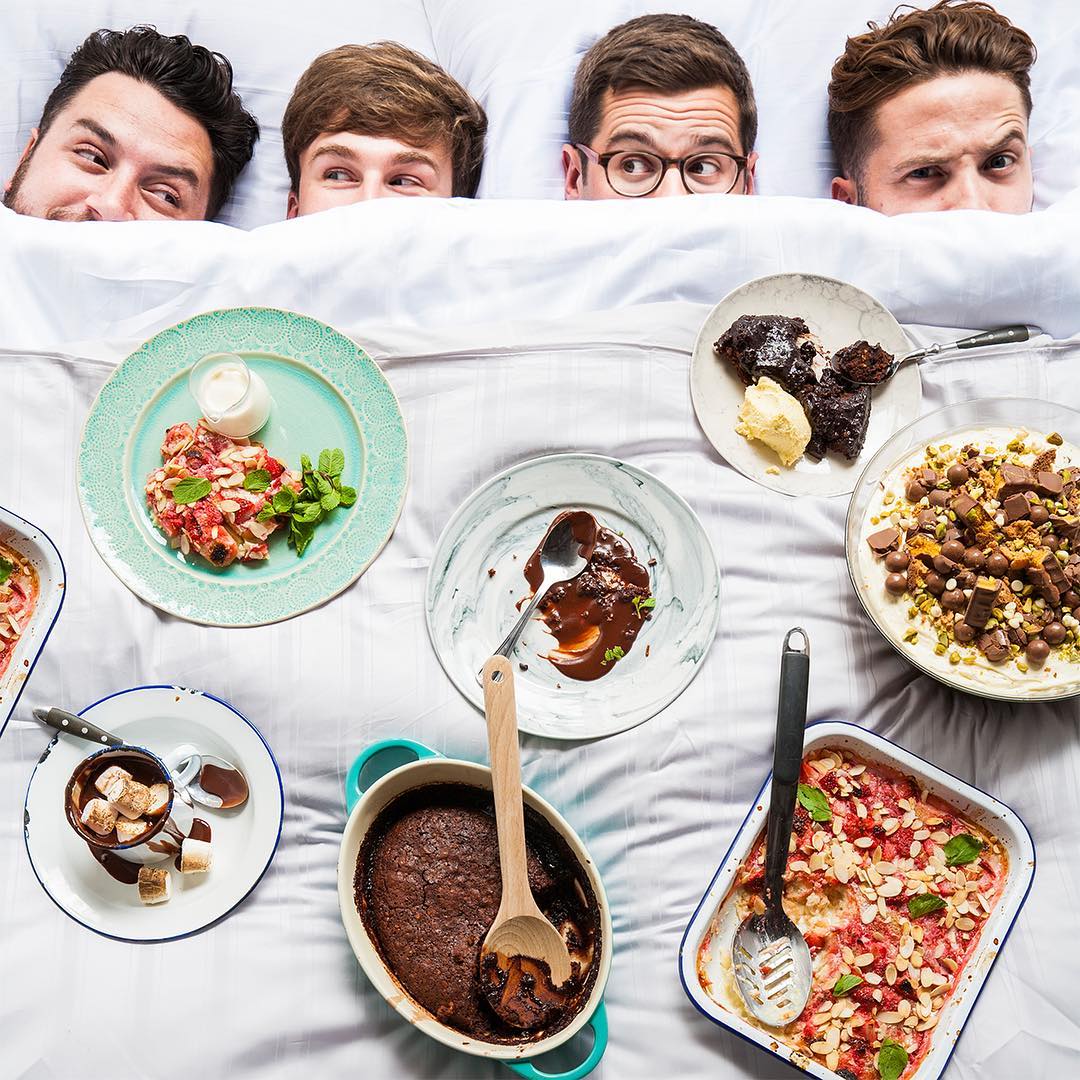 Τα μέλη του SORTEDfood στο κρεβάτι με διάφορα γλυκά πιάτα.