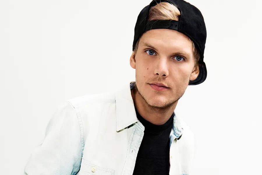 Ο Avicii με μαύρο καπέλο και λευκό πουκάμισο.