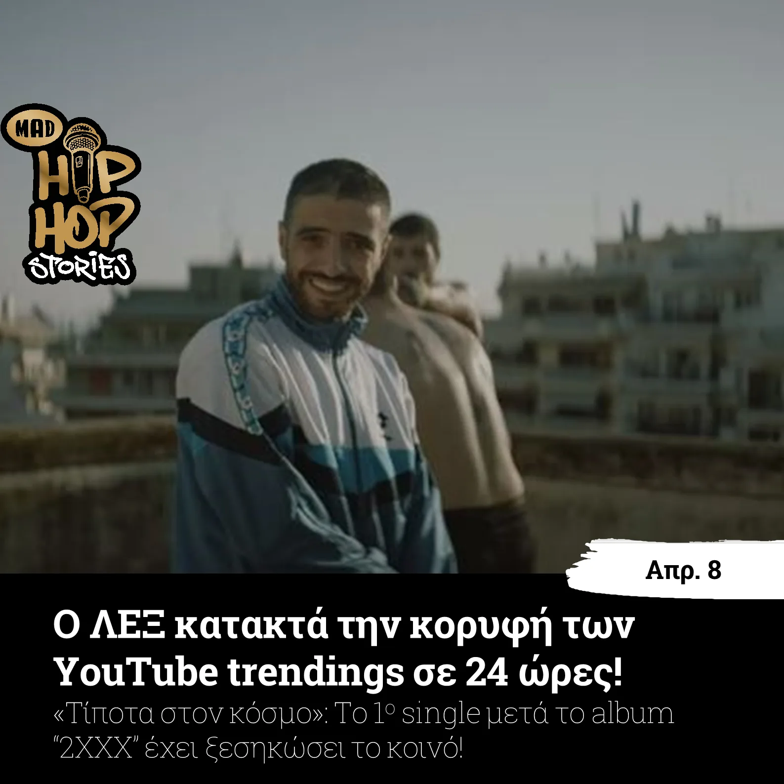 Ο ΛΕΞ χαμογελάει φορώντας αθλητική ζακέτα σε εξωτερικό χώρο.