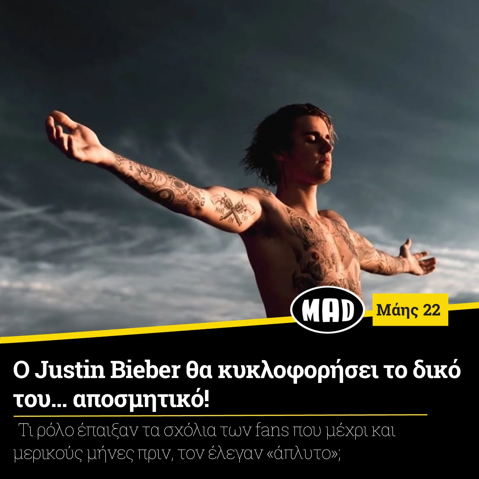 Ο Justin Bieber με ανοιχτά χέρια και τατουάζ μπροστά από τη θάλασσα.
