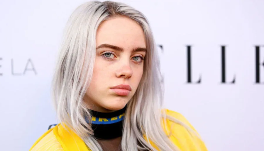 Η Billie Eilish με γκρίζα μαλλιά και κίτρινο ρούχο σε εκδήλωση.