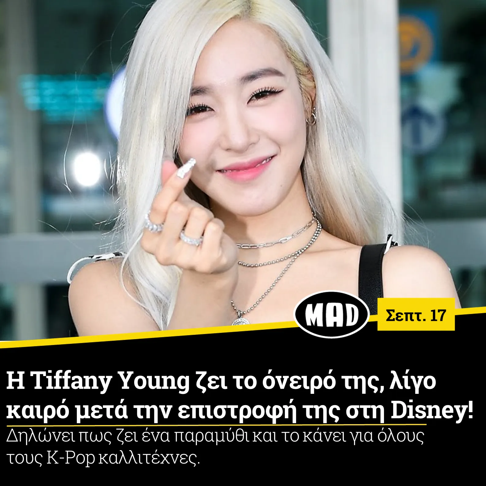 Η Tiffany Young με ξανθά μαλλιά χαμογελά και κάνει το σήμα της καρδιάς με τα δάχτυλα.