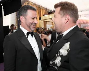 Δύο άνδρες με σμόκιν γελούν στο μωβ χαλί των Emmy Awards 2019.
