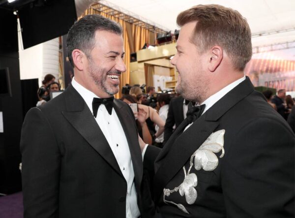 Δύο άνδρες με σμόκιν γελούν στο μωβ χαλί των Emmy Awards 2019.