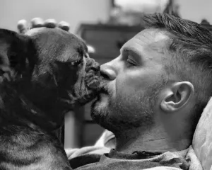 Ασπρόμαυρη φωτογραφία του Tom Hardy με τον σκύλο του.
