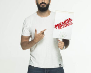 Ο Λάμπρος Φισφής κρατάει πινακίδα Premise Comedy Club.