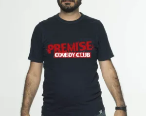 Ο κωμικός Πάρης Ρούπος με μπλε t-shirt Premise Comedy Club.