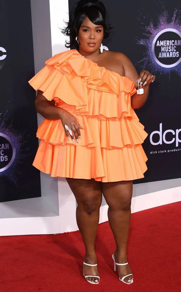 Η Lizzo με πορτοκαλί φόρεμα με βολάν στα American Music Awards.
