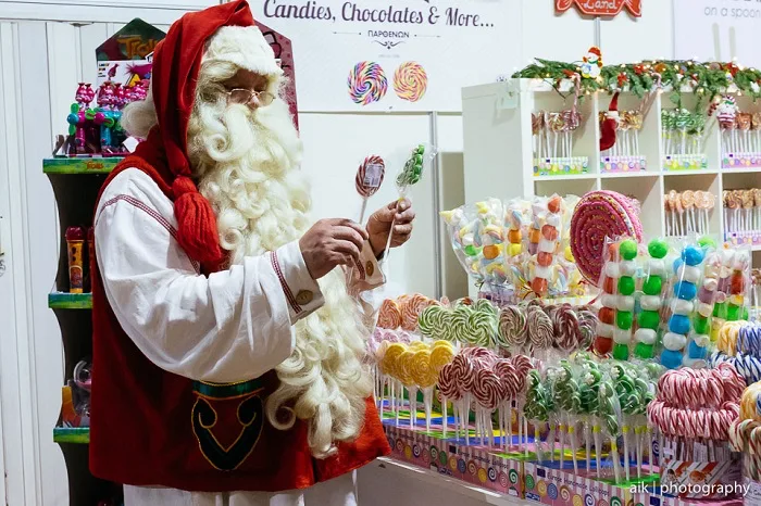 Ο Santa Claus κοιτάζει γλειφιτζούρια σε ένα χριστουγεννιάτικο κατάστημα με ζαχαρωτά.