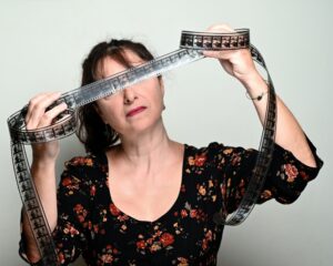 Η Ηλέκτρα Γεννατά κρατάει μια κινηματογραφική ταινία μπροστά στα μάτια της.