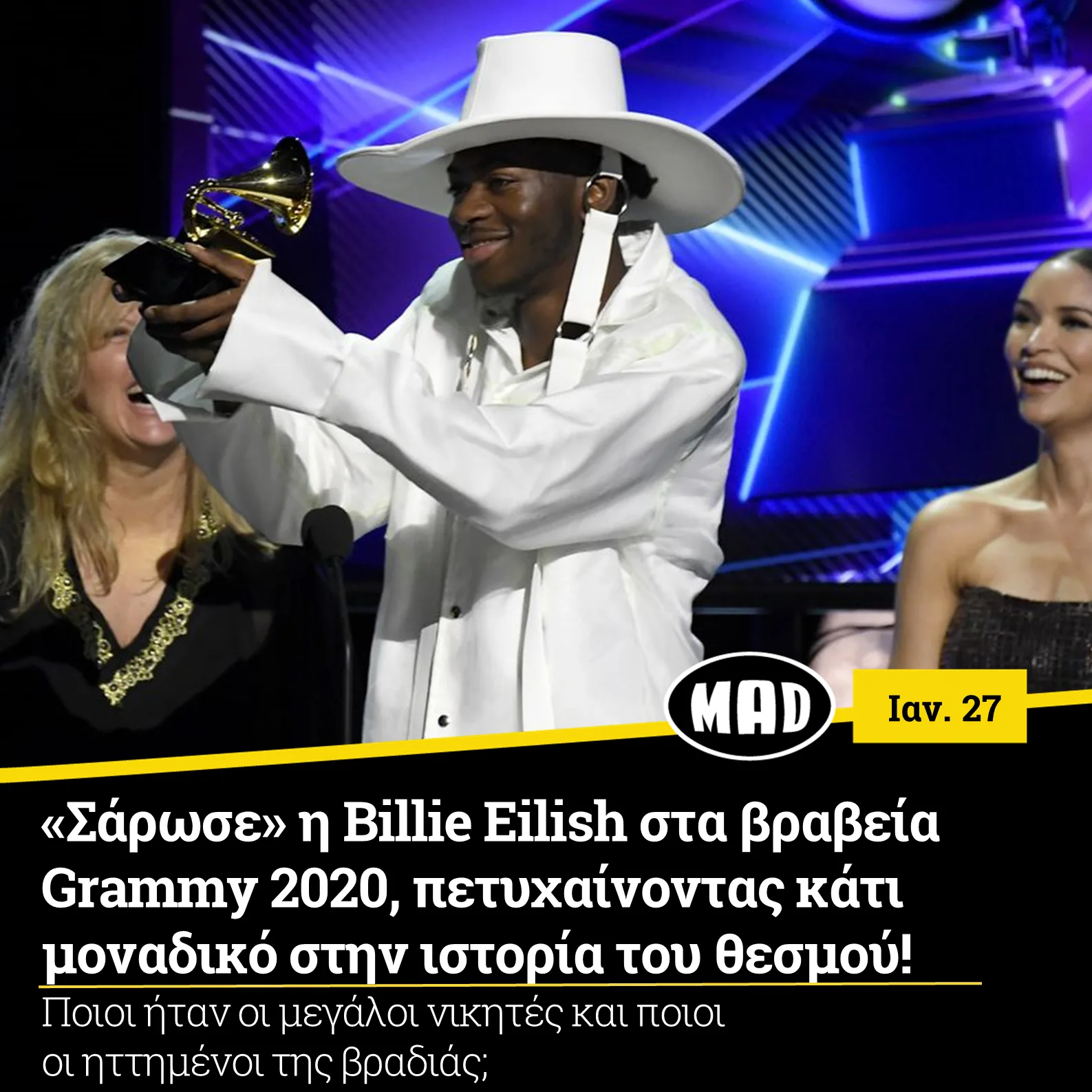 Ο Lil Nas X κρατάει βραβείο Grammy στη σκηνή.