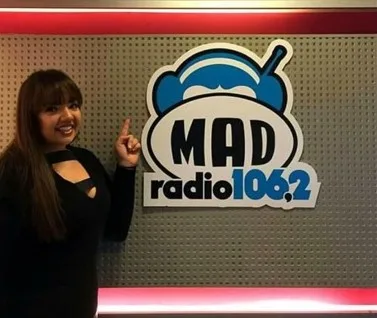 Γυναίκα δείχνει το λογότυπο του Mad Radio 106.2