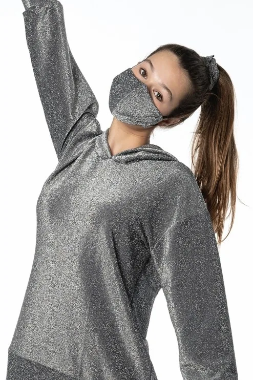 Μοντέλο με γκρι αστραφτερό hoodie και ασορτί προστατευτική μάσκα προσώπου.